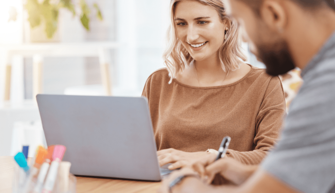A smiling leader talking to their dispersed team on their laptop